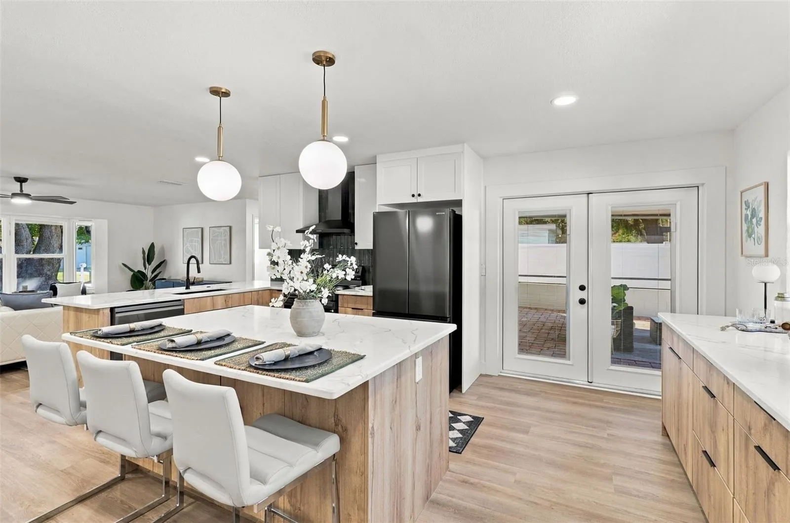 Beautifully updated kitchen featuring quartz countertops, stainless steel appliances, and French doors leading to the outdoor living area.