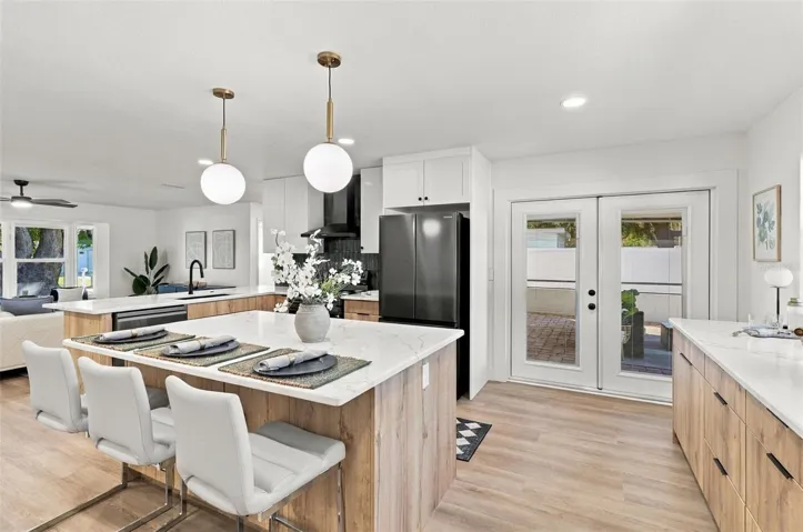Beautifully updated kitchen featuring quartz countertops, stainless steel appliances, and French doors leading to the outdoor living area.