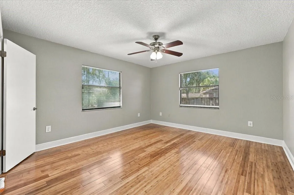 Primary bedroom is split from the other bedrooms, ceiling fan, walk in closet, new blinds and bamboo hardwood flooring.