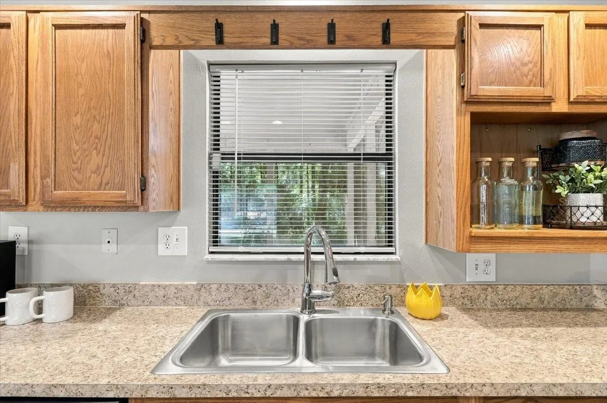 Kitchen window has a bar to the porch. Wash the dishes with a view!