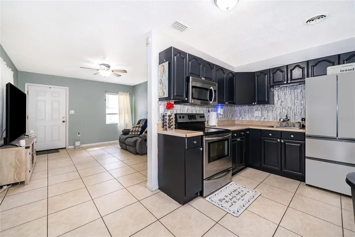 Enjoy preparing meals in this functional kitchen featuring dark cabinetry, ample countertop space, and easy access to the dining area.