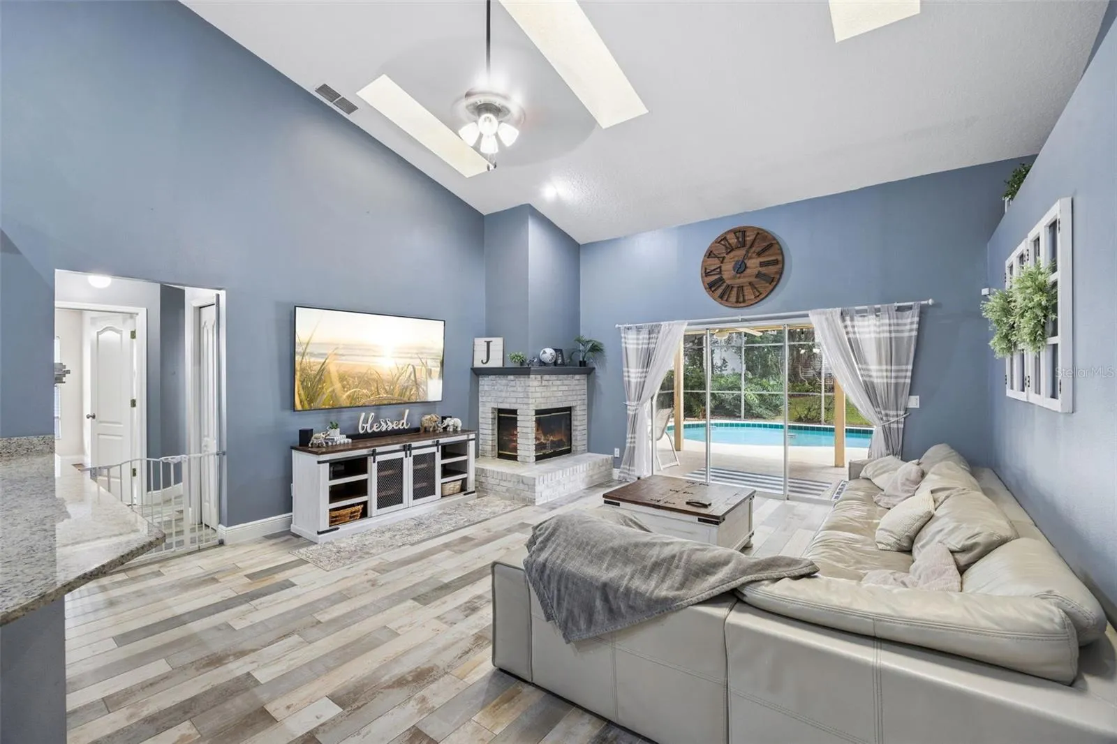 1505 Grassy Ridge Ln- Family room with vaulted ceiling, fireplace, and pool view