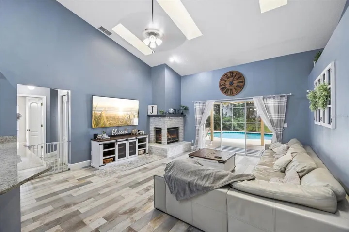 1505 Grassy Ridge Ln- Family room with vaulted ceiling, fireplace, and pool view