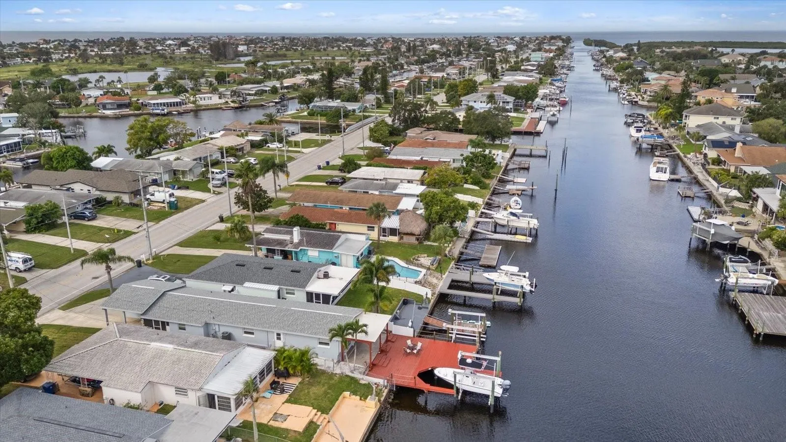 Aerial view of home with red deck and boat lift in North Channel looking west.