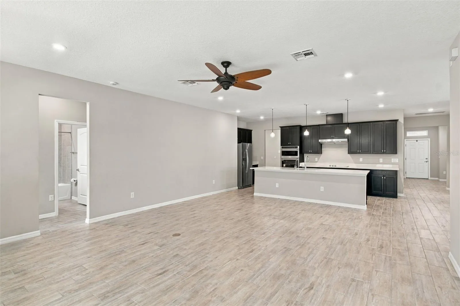 Living Room with ceiling fan, Kitchen in background