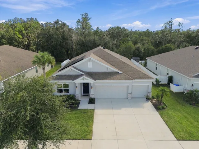 Overhead view of home's front exterior with conservation in background