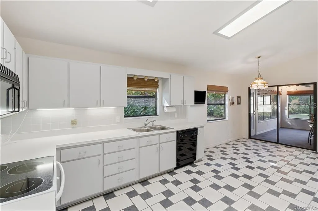 A KITCHEN WITH ROOM TO MOVE! Generous countertop space, abundant cabinetry, DOUBLE-BASIN SINK &amp; convenient access to the ENCLOSED FLORIDA ROOM!