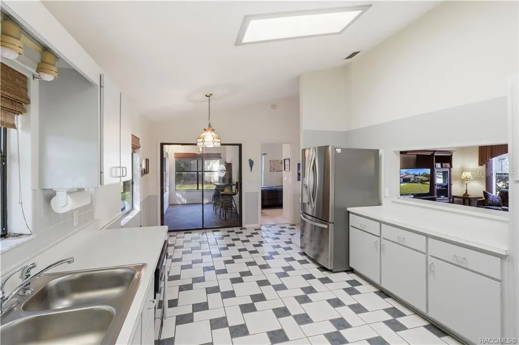 THE HEART OF THE HOME! Functional kitchen layout offers GRAY CABINETRY, STAINLESS STEEL REFRIGERATOR, PASS-THROUGH TO LIVING ROOM &amp; convenient access to adjoining spaces!