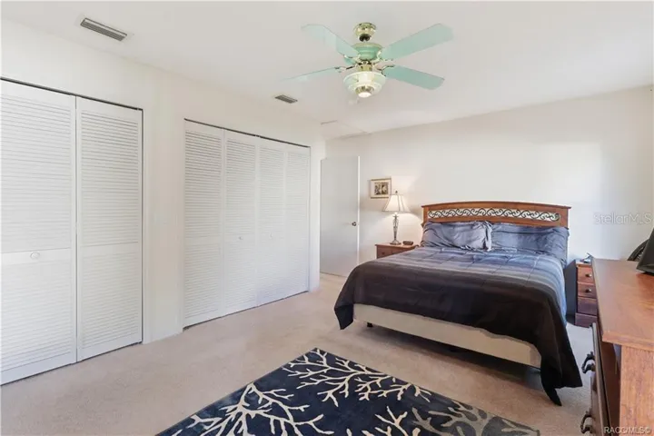 ROOM TO RELAX! PRIMARY SUITE features GENEROUS CLOSET SPACE w/multiple louvered closet doors, soft neutral carpeting &amp; ceiling fan!