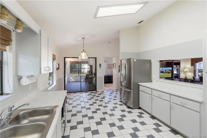 THE HEART OF THE HOME! Functional kitchen layout offers GRAY CABINETRY, STAINLESS STEEL REFRIGERATOR, PASS-THROUGH TO LIVING ROOM &amp; convenient access to adjoining spaces!