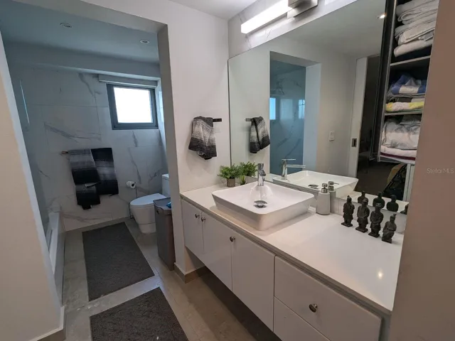 Bathroom – marble-look tile and vessel-sink vanity