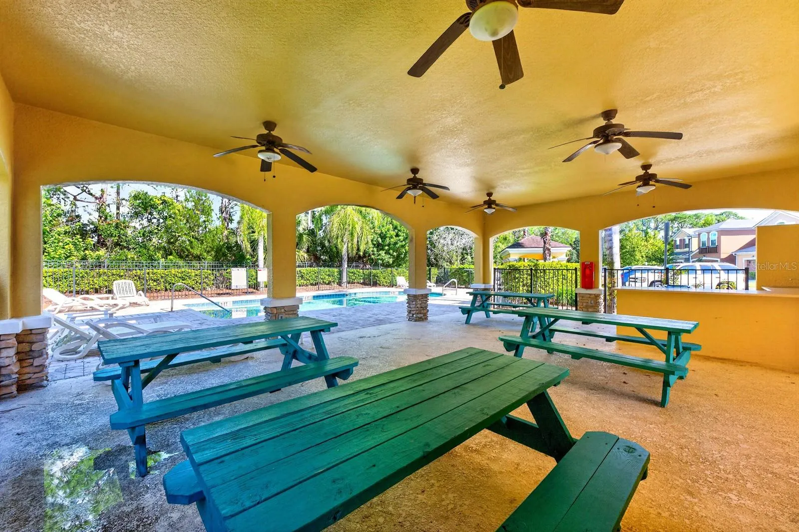 Covered patio with picnic tables near the pool