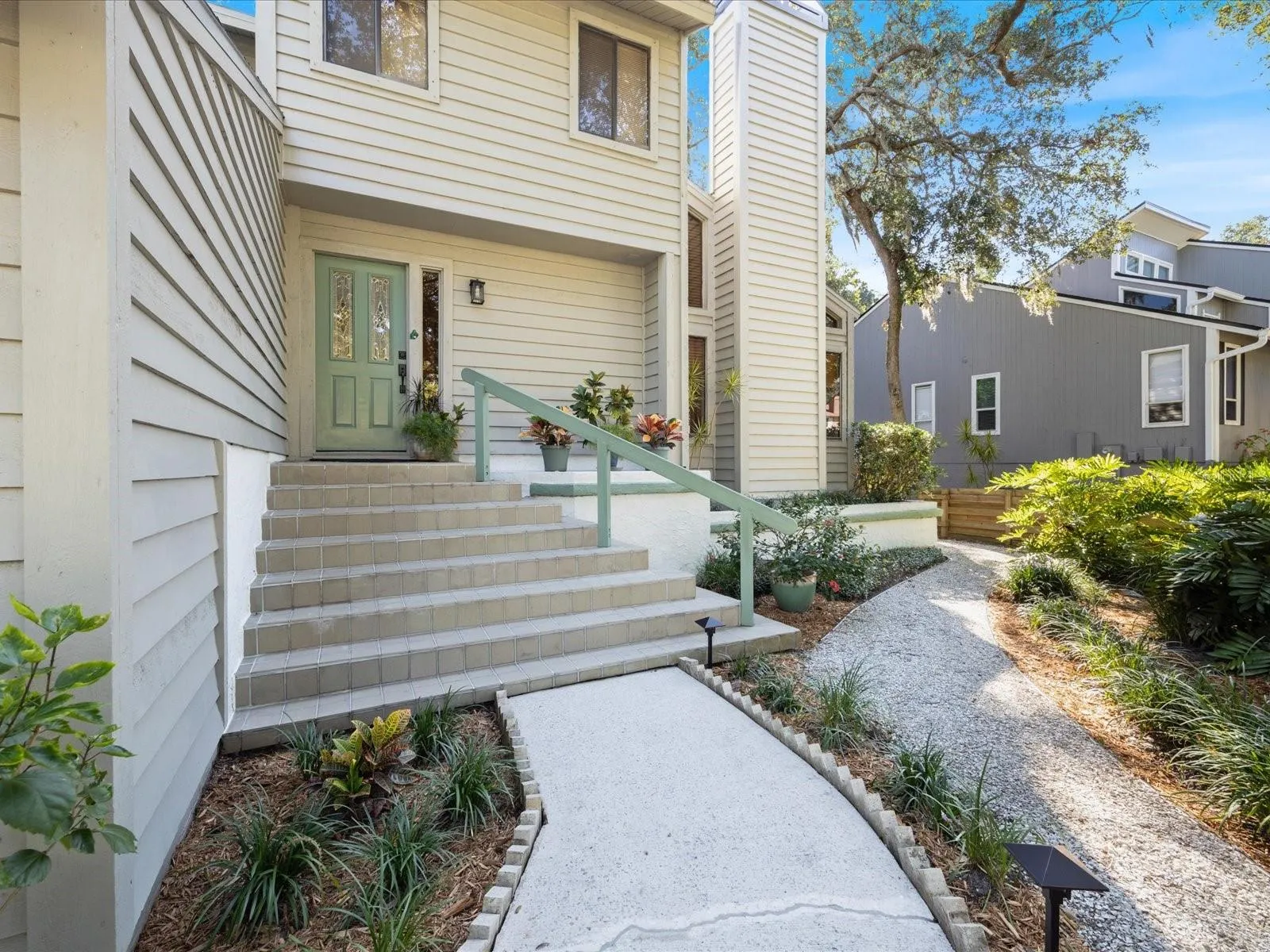 Stairs leading into hom with part of the beautiful zero scaping seen