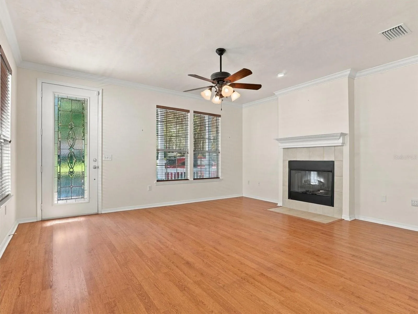 Living Room with beautiful front door, fireplace and ceiling fans.