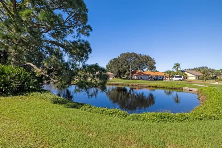Serene pond along the side of the home, a peaceful water view.