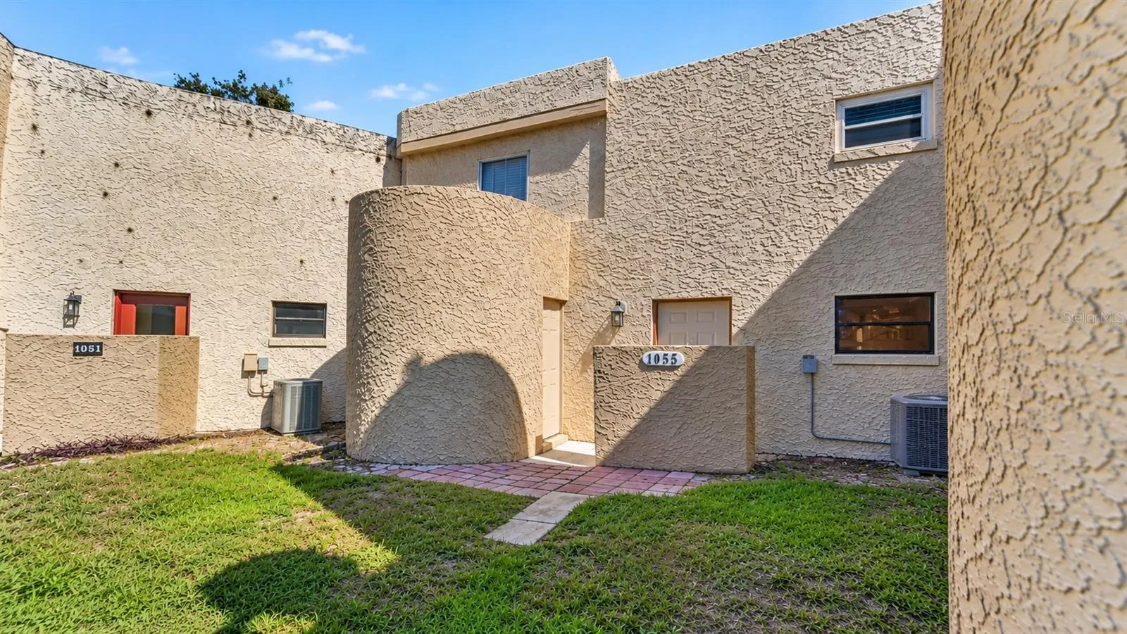 Charming Courtyard Setting With Textured Stone Exteriors and Manicured Landscaping