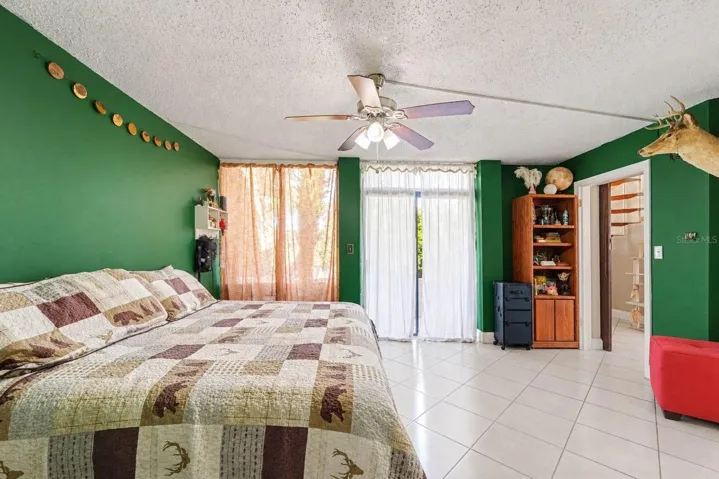 Master Bedroom with Green Walls, Mounted Deer Head &amp; Sliding Glass Doors
