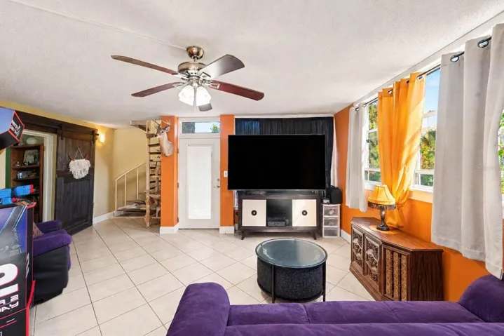 Spacious Living Room with Orange Accent Walls &amp; Entertainment Setup