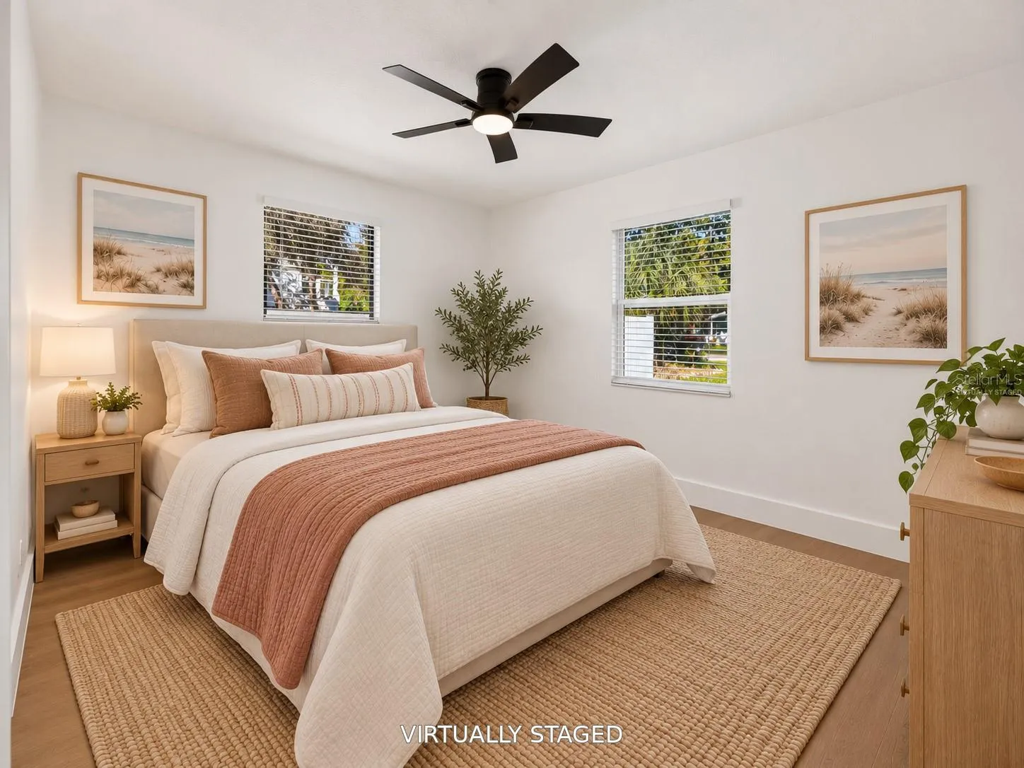 VIRTUALLY STAGED. Bright secondary bedroom featuring updated flooring and a modern black ceiling fan.