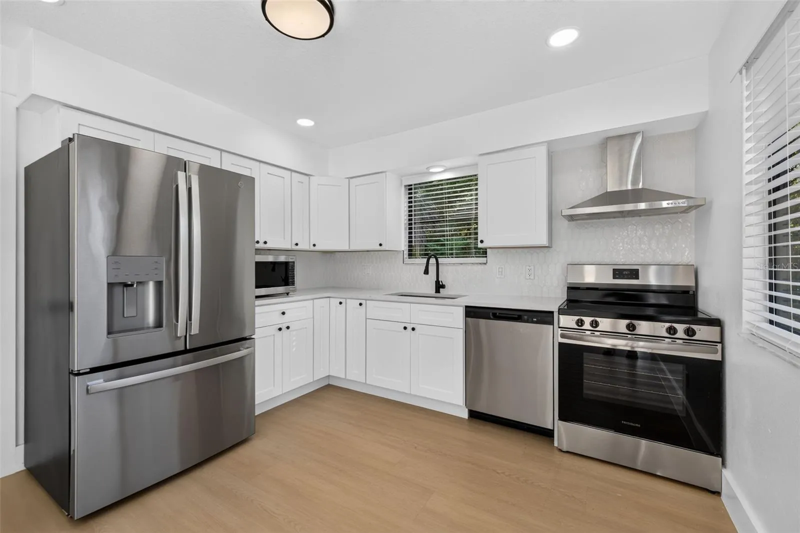 Updated kitchen featuring quartz countertops and stainless steel appliances.