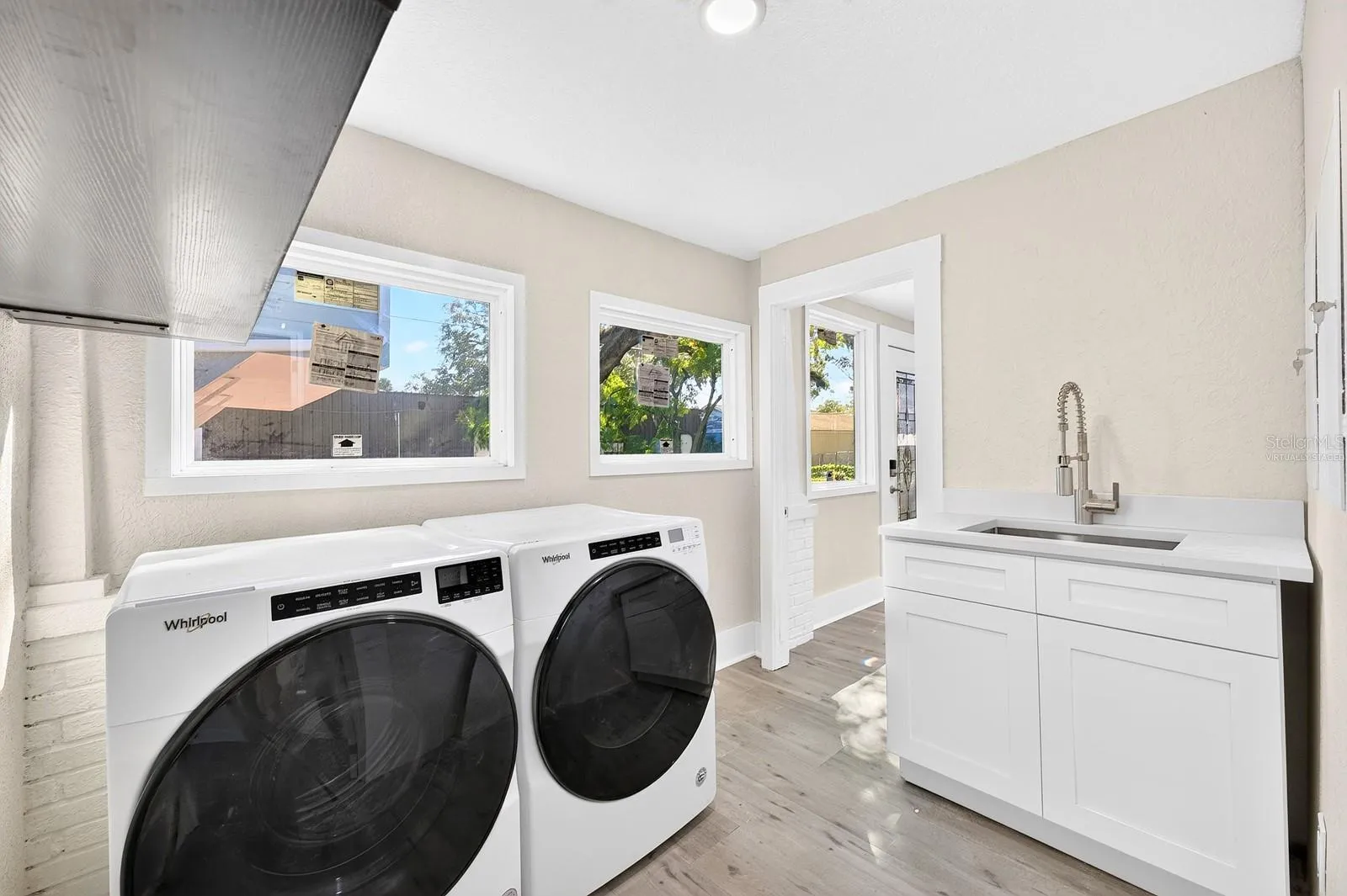 The dedicated Laundry Room includes the washer and dryer, along with EXTRA STORAGE and a vanity with sink.