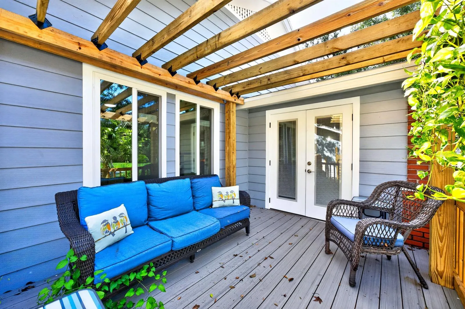 Double doors open to a beautiful side porch with a PERGOLA—a lovely spot to relax and enjoy the character of the property.