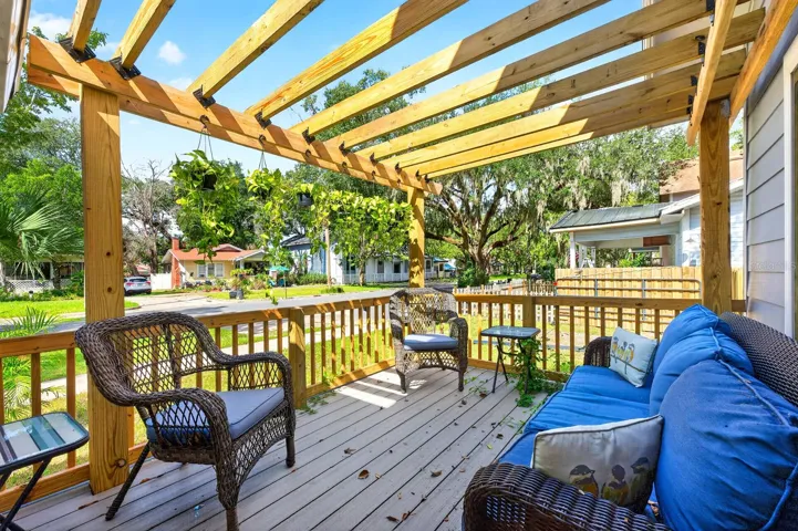 Double doors open to a beautiful side porch with a PERGOLA—a lovely spot to relax and enjoy the character of the property.