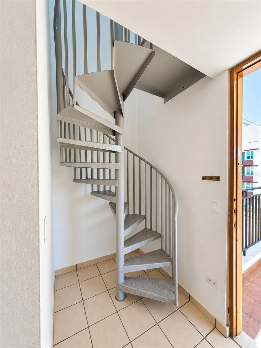 Interior spiral staircase connecting the main level to the upper-level terrace.