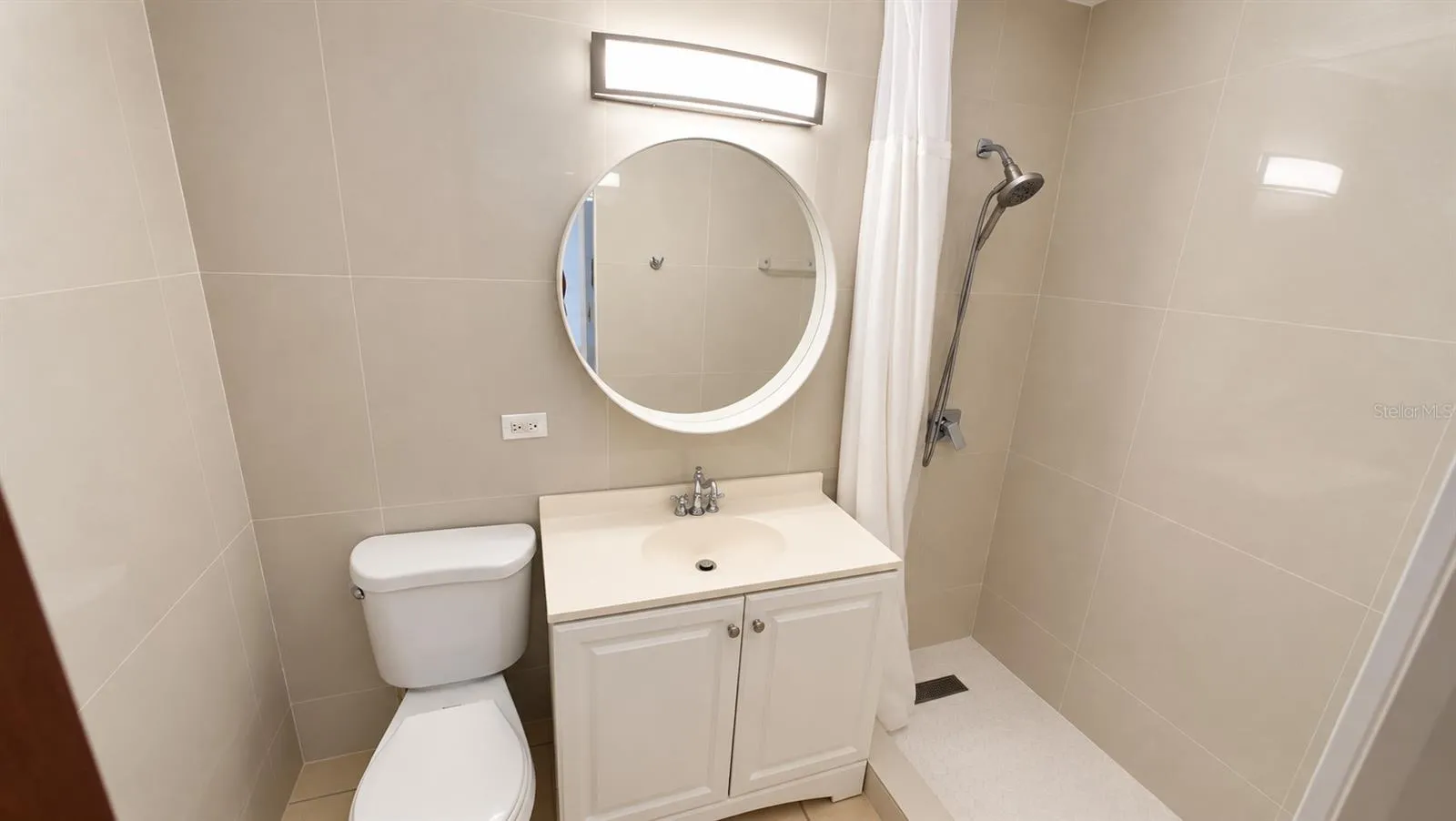 Hall bathroom with vanity and walk-in shower.