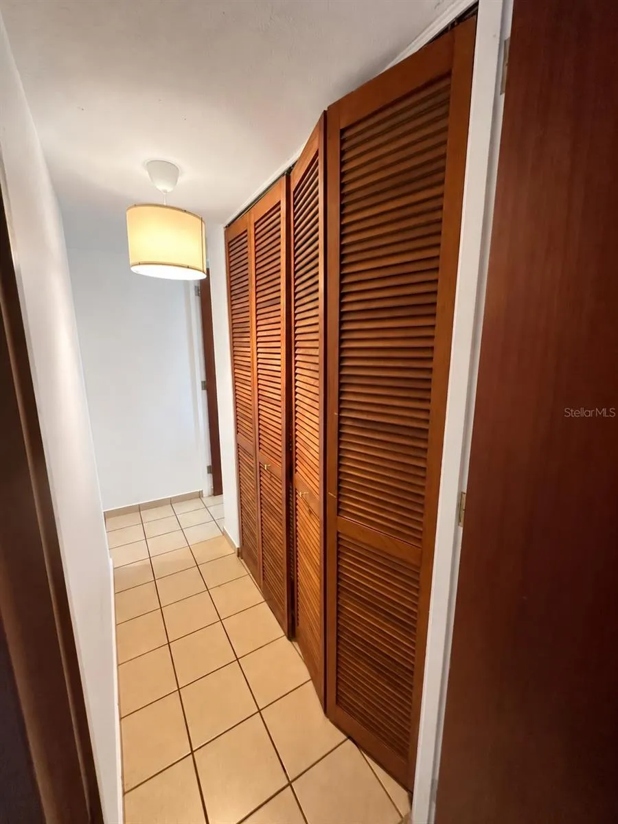 Interior hallway with louvered doors enclosing the laundry area.