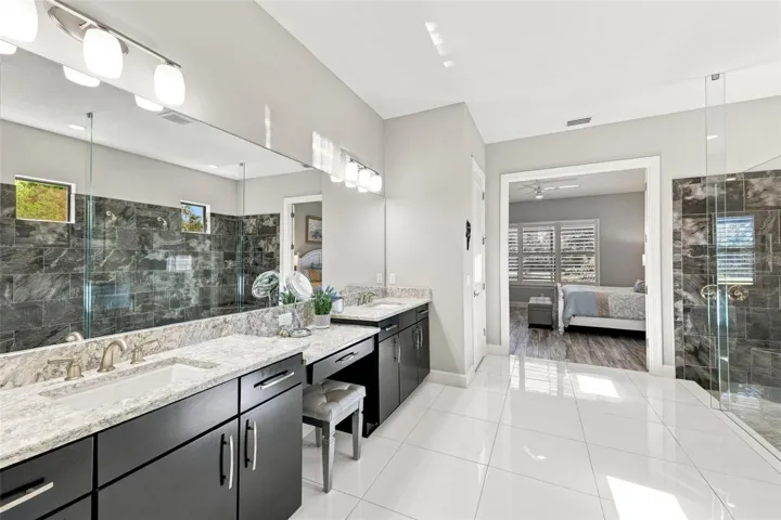 Primary Bathroom shower with dual sinks and vanity