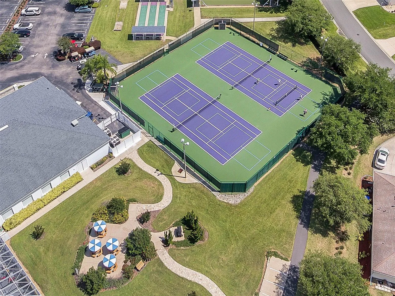 Courts and shaded seating near the clubhouse.