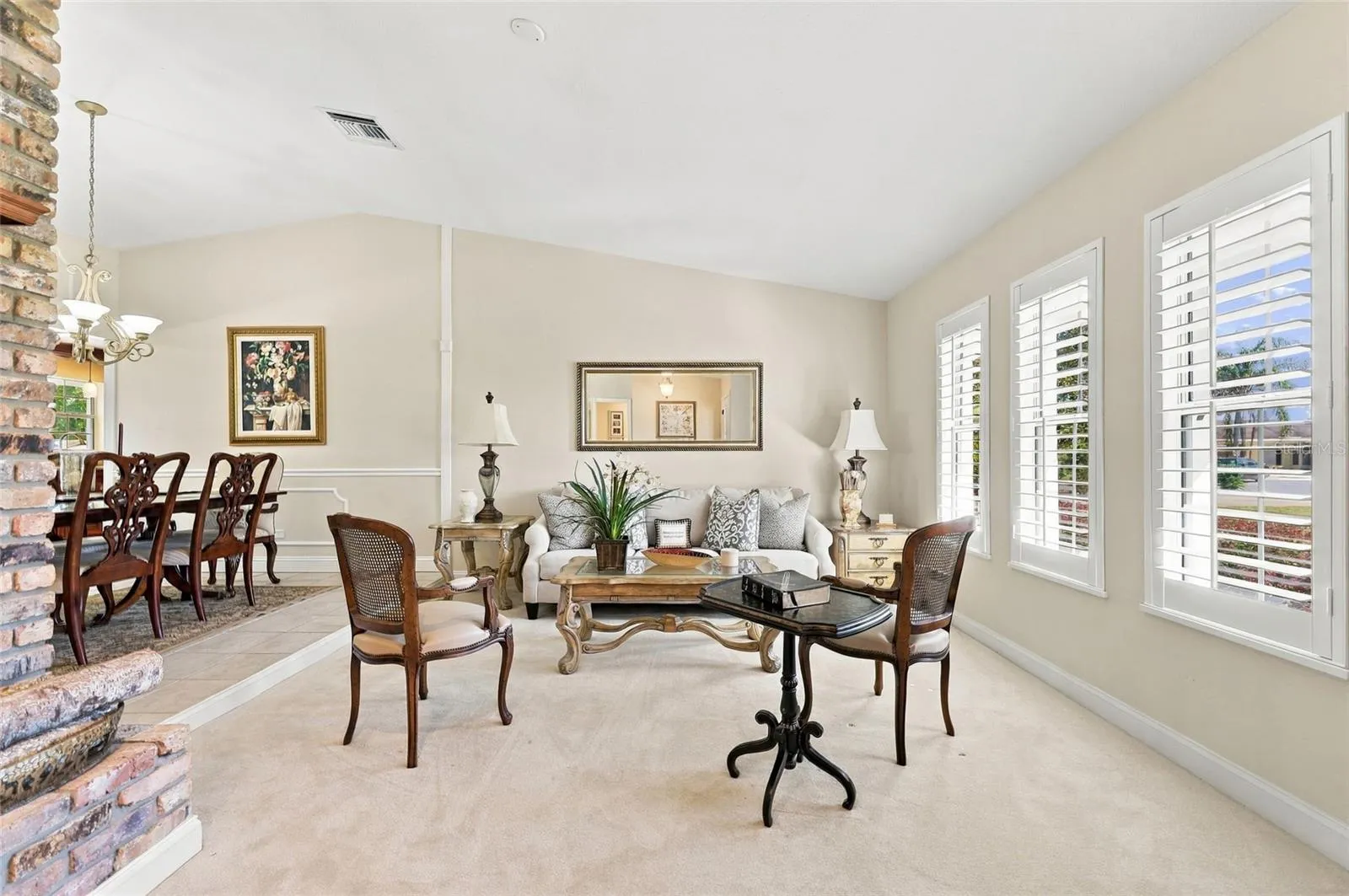 Living Room with plantation shutters &amp; wood burning fireplace