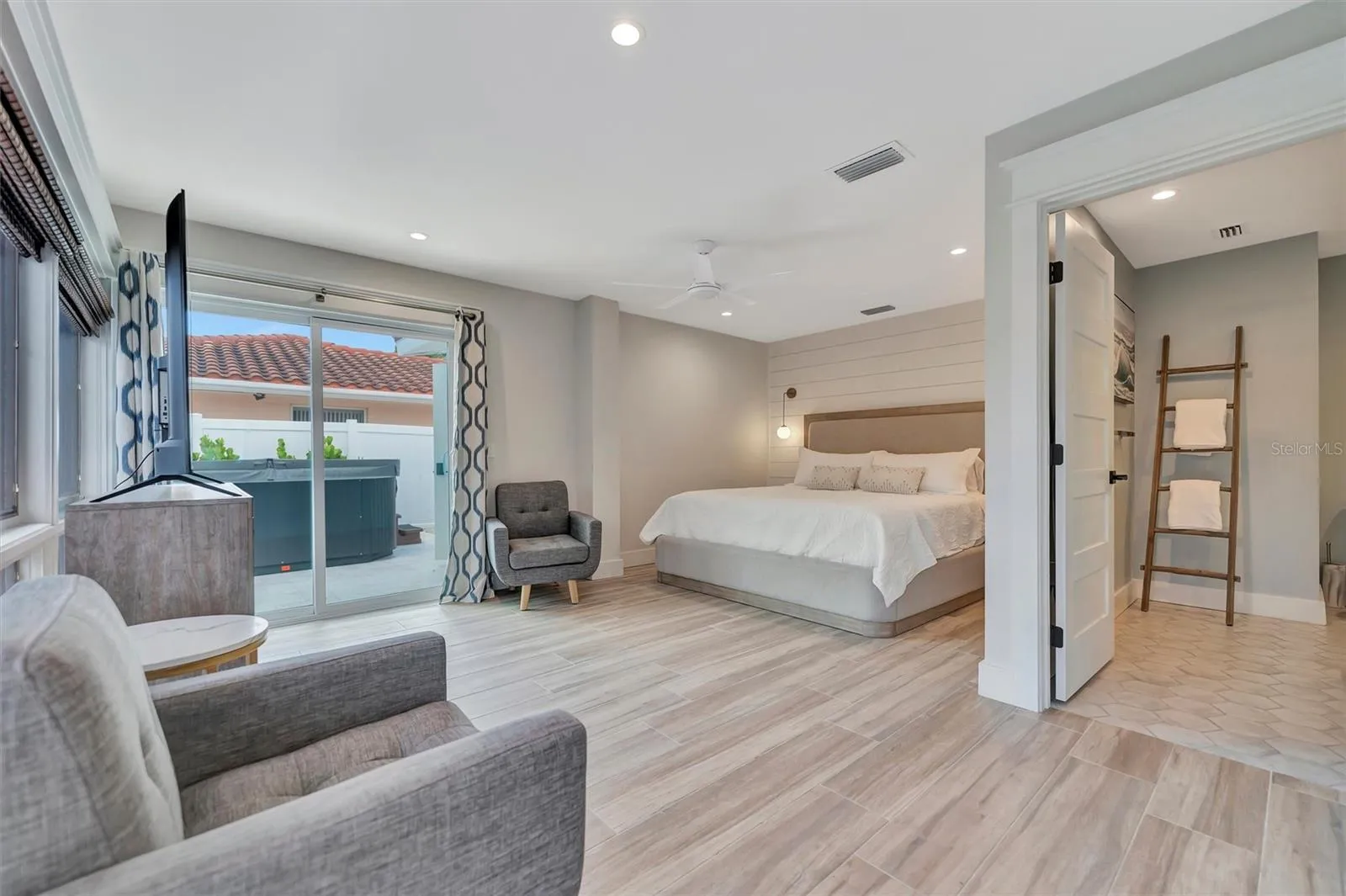 Primary suite with sliding glass doors, gorgeous views of the pool, turf area, and canal, plus an ensuite bathroom.