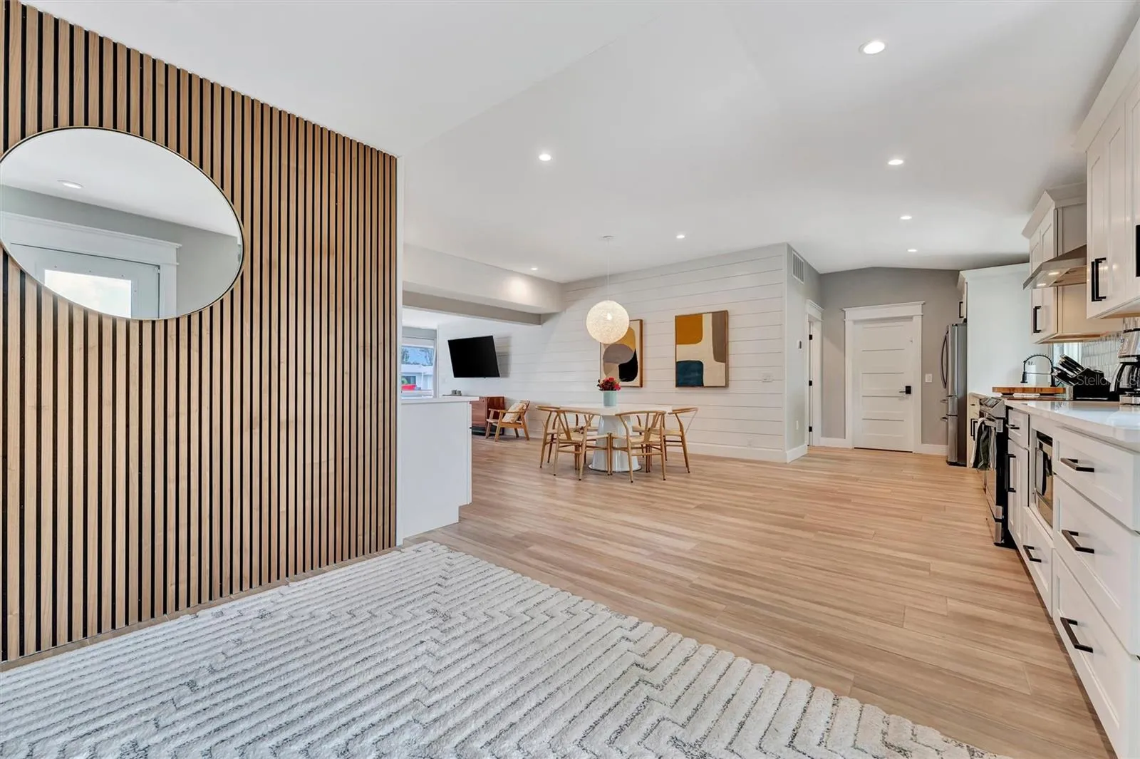 Extensively updated with 2023 roof, 2022 AC, newer rear windows, flood barriers, wood-look tile, neutral finishes, and open living/dining area.