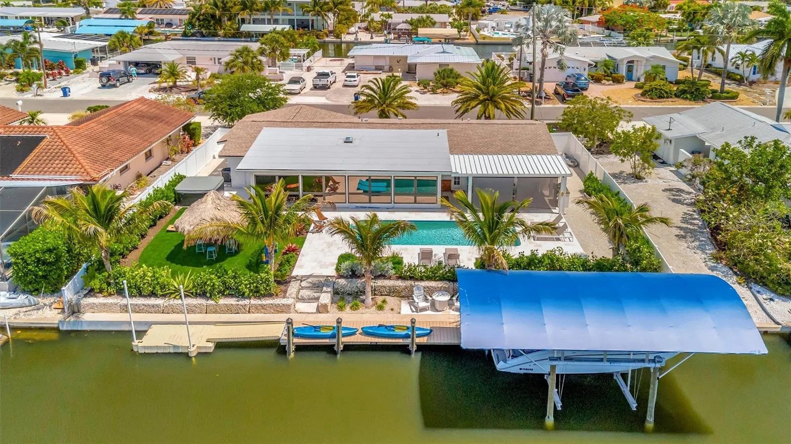 Extensively updated with 2023 roof, 2022 AC, newer rear windows, flood barriers, wood-look tile, neutral finishes, and open living/dining area.