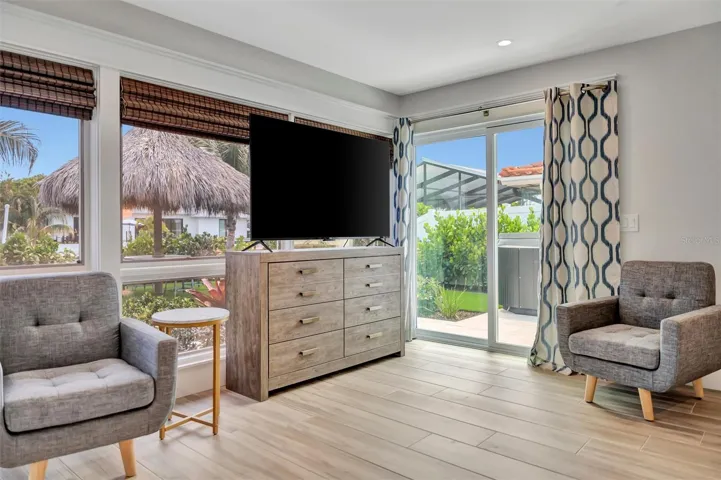 Primary suite with sliding glass doors, gorgeous views of the pool, turf area, and canal, plus an ensuite bathroom.