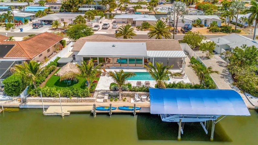 Extensively updated with 2023 roof, 2022 AC, newer rear windows, flood barriers, wood-look tile, neutral finishes, and open living/dining area.