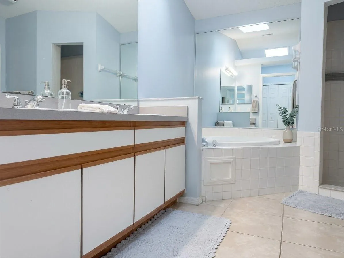 En-suite primary bathroom features ceramic tile, garden tub, and shower.