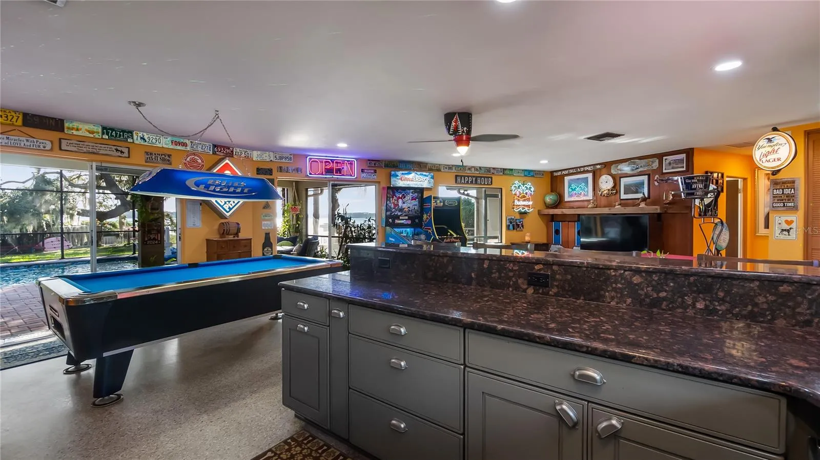 Main Home - Great room/kitchen/living room combo: Living room used as gathering space for game room fun. Two Sliders go out to covered back porch and screened in pool