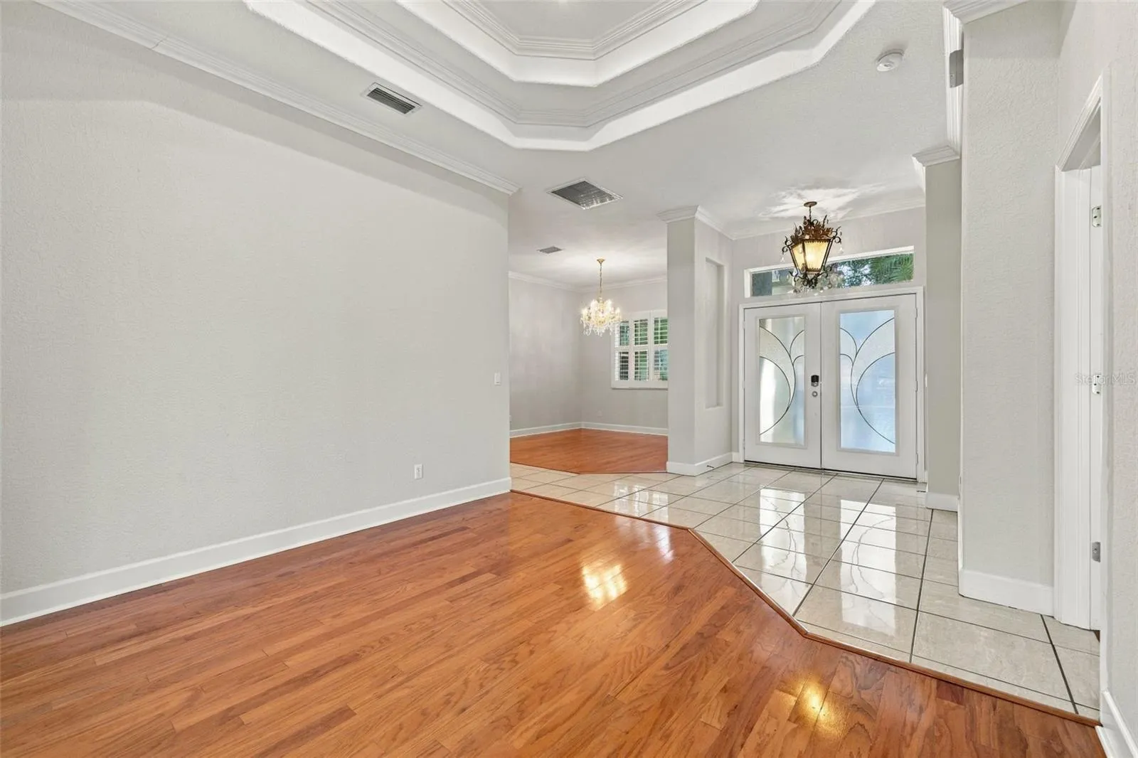 Formal Living Room with Double Step Tray Ceiling adorned in Crown Molding! Real Wood Flooring &amp; 5 1/4 Baseboards