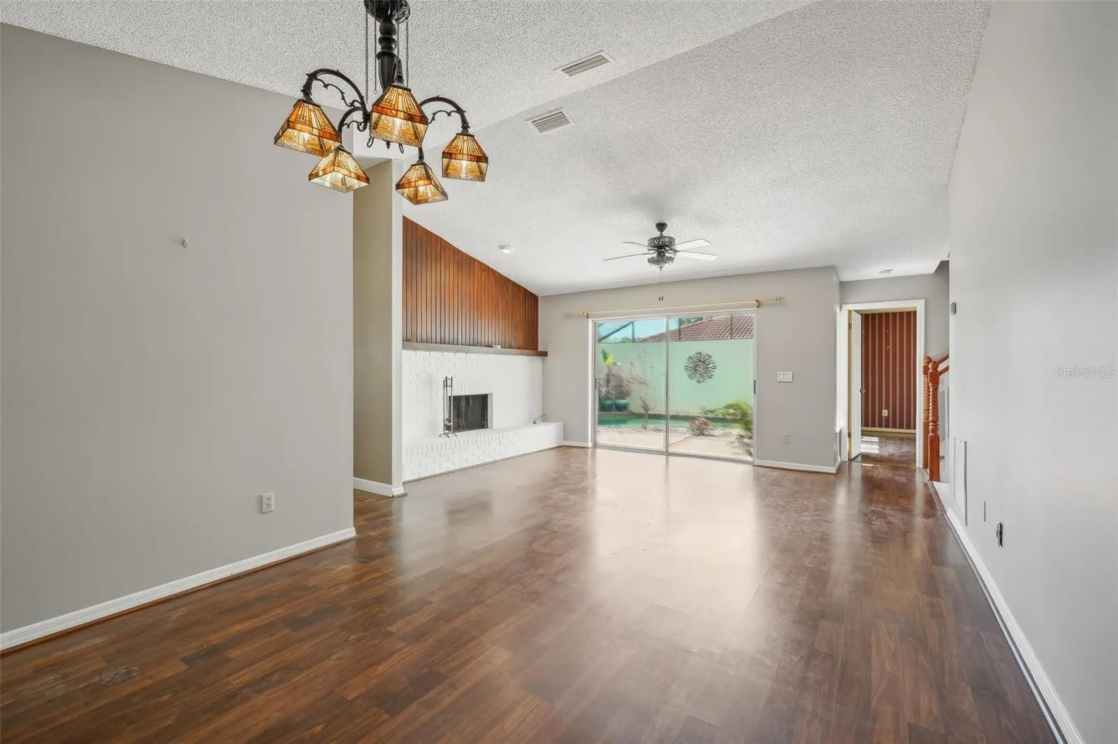 Spacious living room with a wood-burning fireplace, a separate dining room and laminate floors.