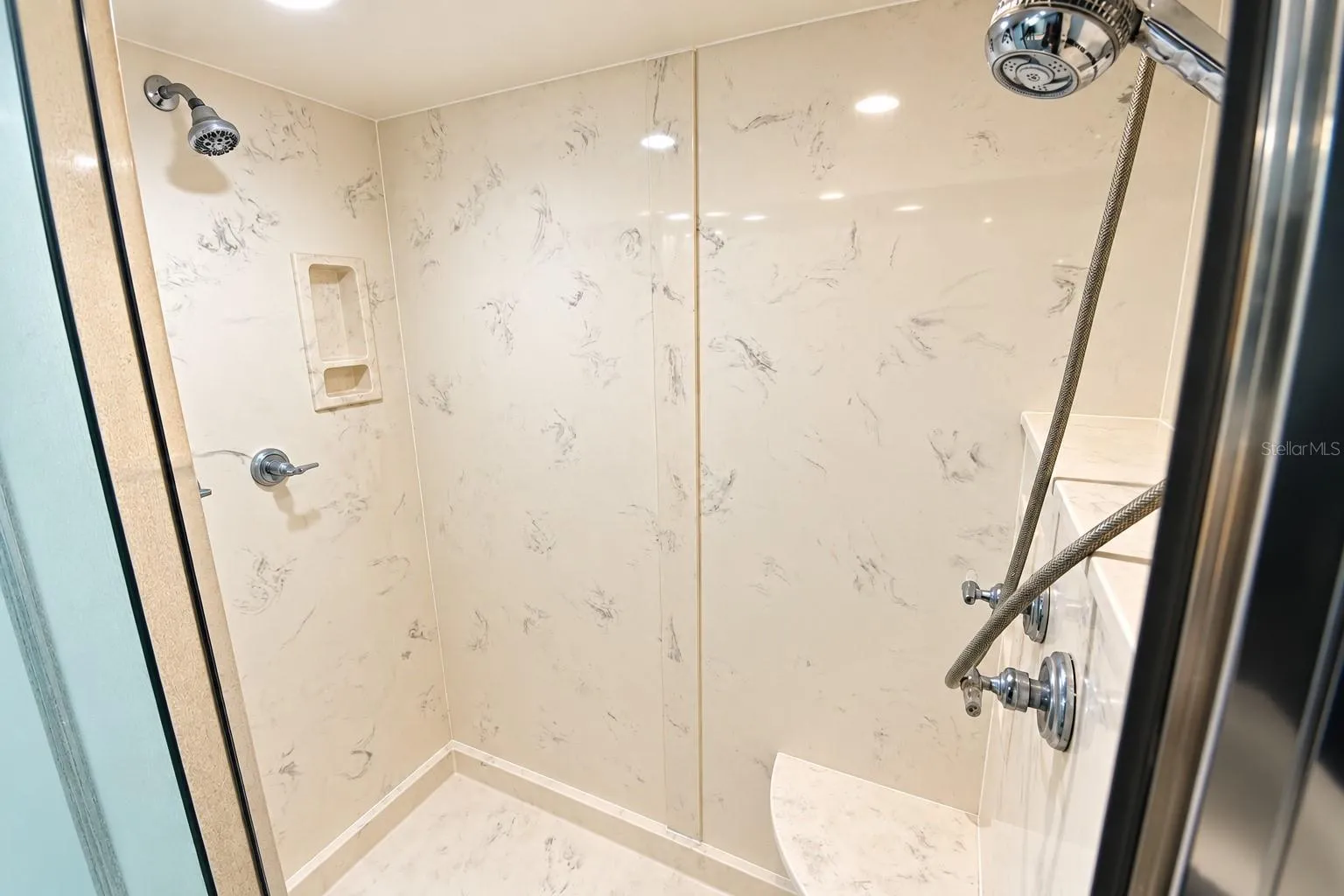 Walk in shower with multiple shower heads.