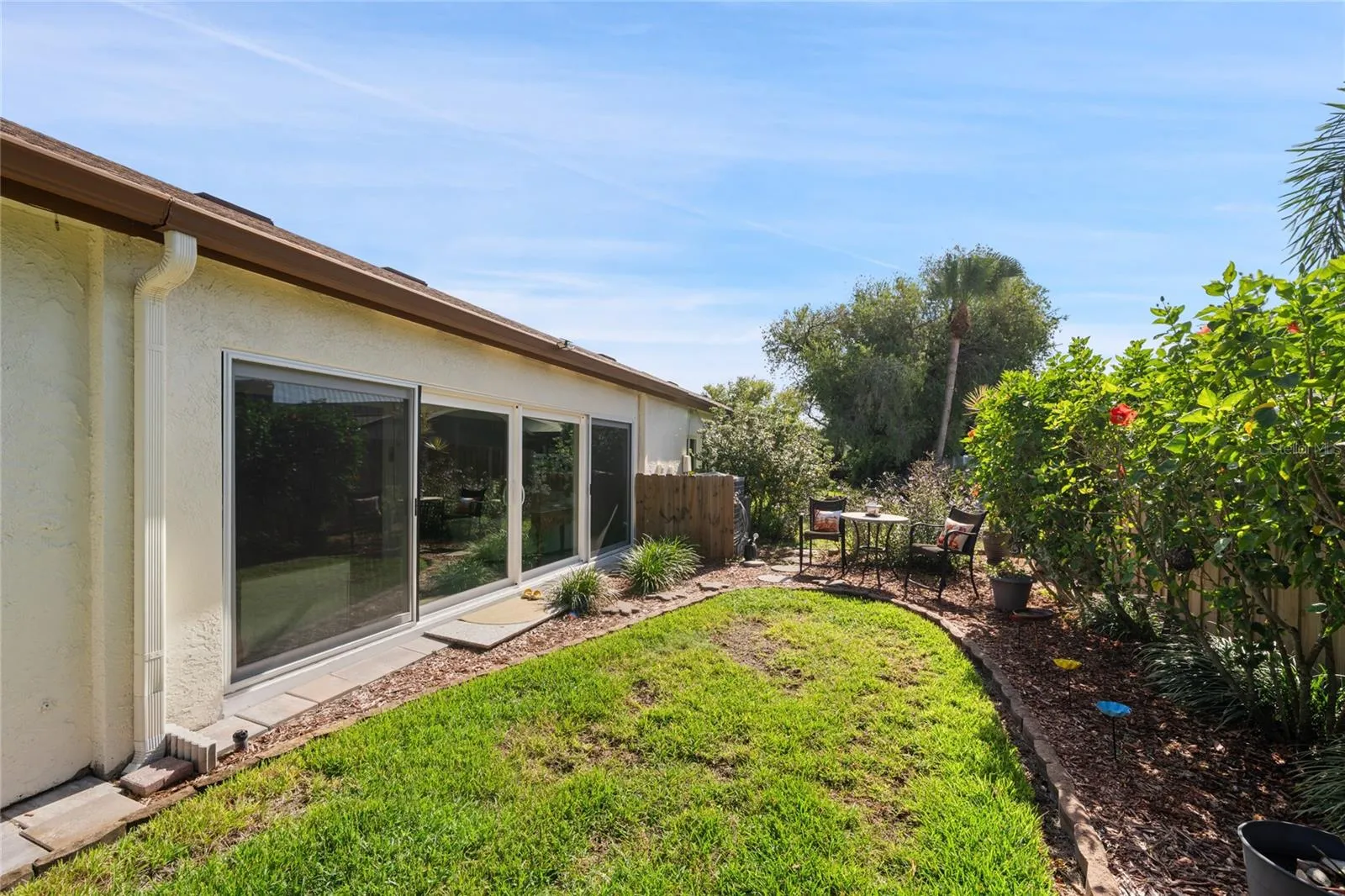 REAR VIEW WITH SEATING AREA.  THERE ARE FRENCH DRAINS FOR STORM DRAINAGE IN BACK YARD.