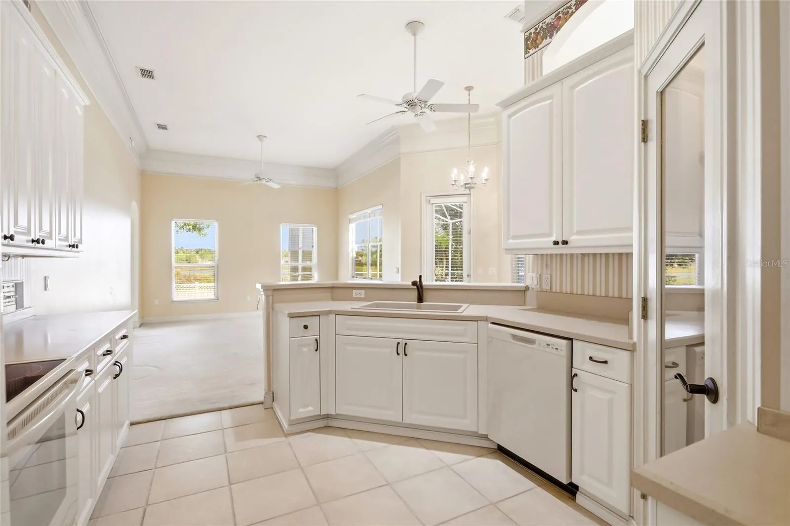 White kitchen cabinetry, generous counter space, and a breakfast bar connect the kitchen tothe family room and breakfast nook.