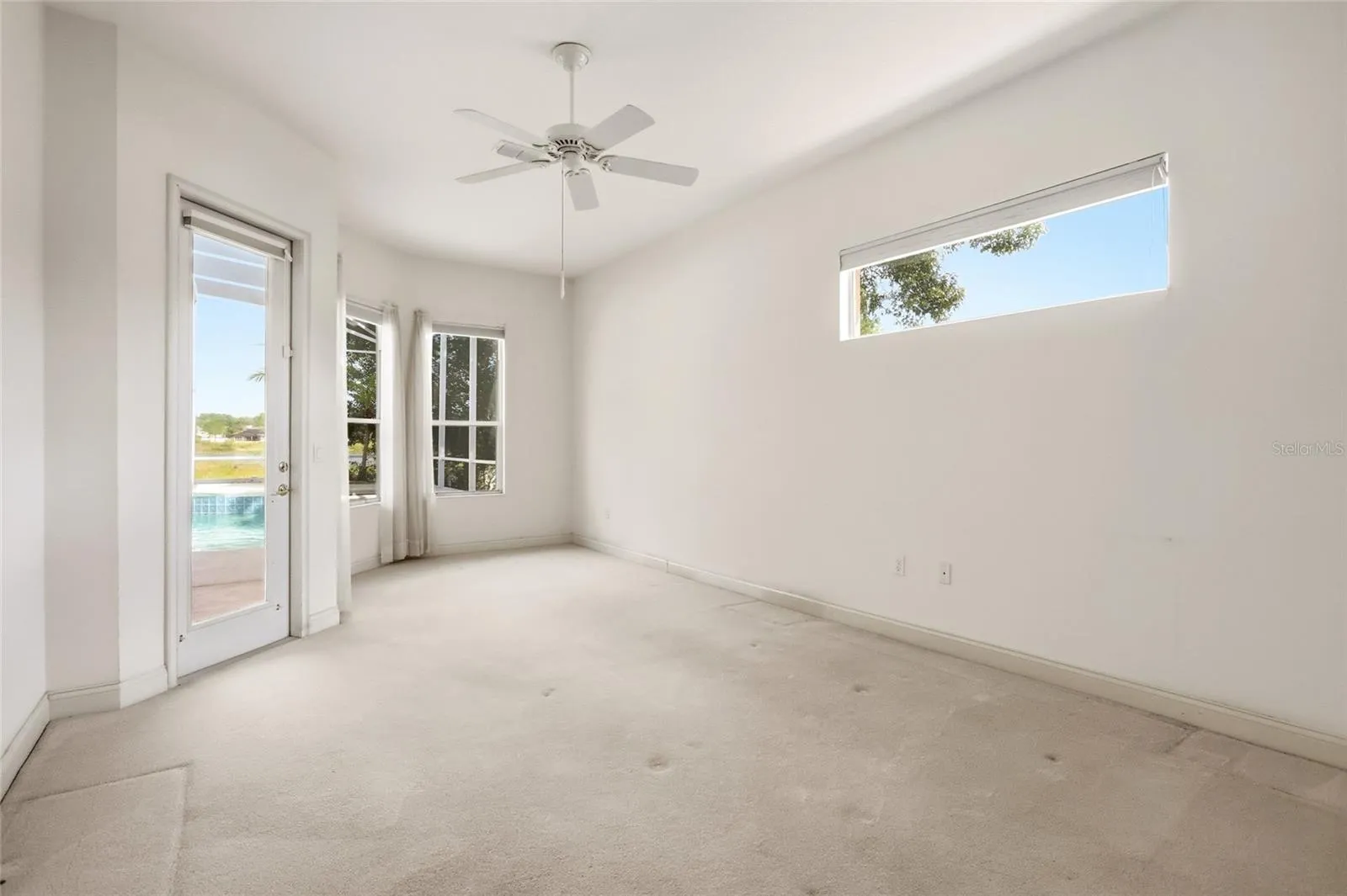 Primary suite in a three-way split bedroom plan, with direct access to the covered porch andscreened pool.