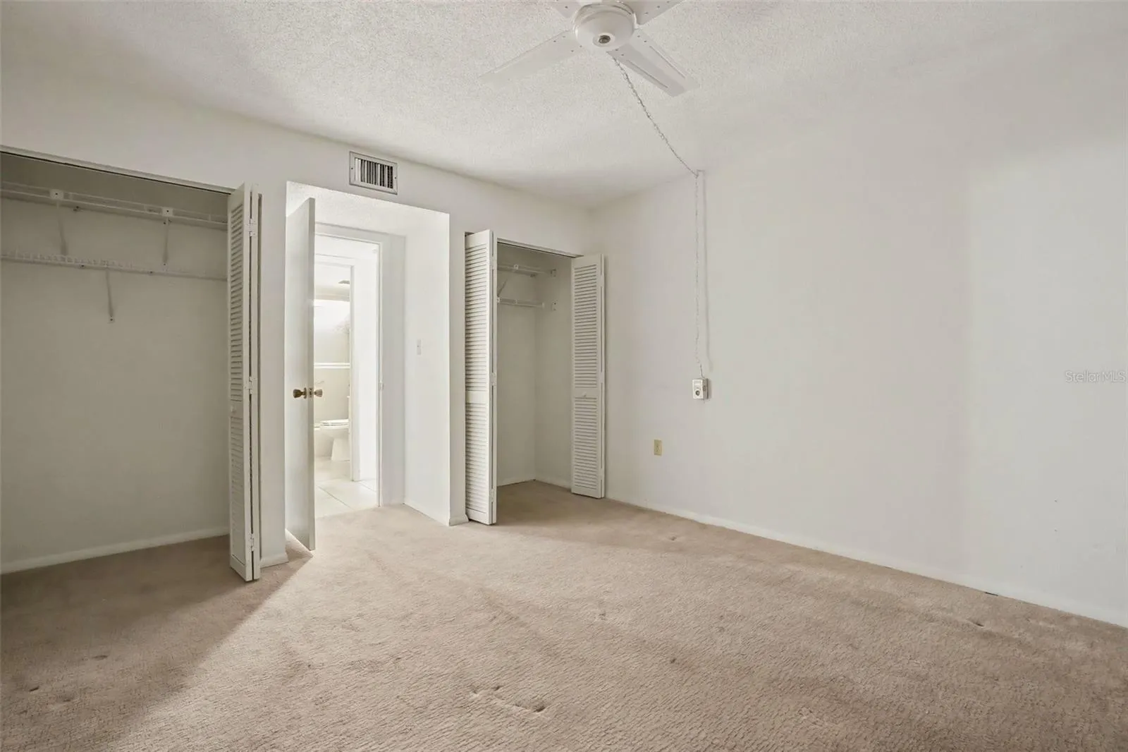 Guest bedroom with two closets with bifold doors, ceiling fan, and easy access to the guest bathroom.
