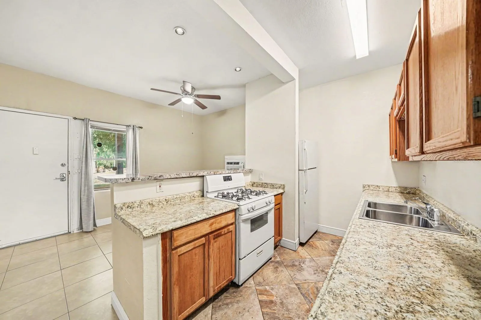 Open Kitchen Layout with Island, Gas Range & Access to Backyard