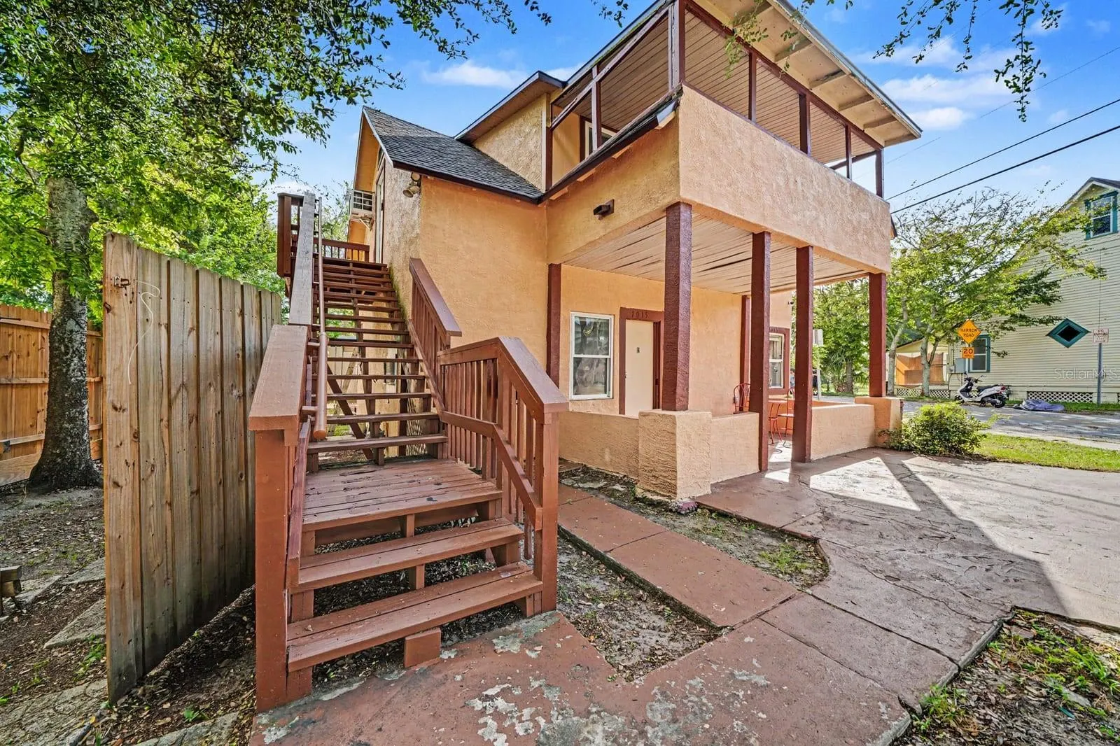 Elevated Home With Red Wooden Stairs & Ground-Level Access