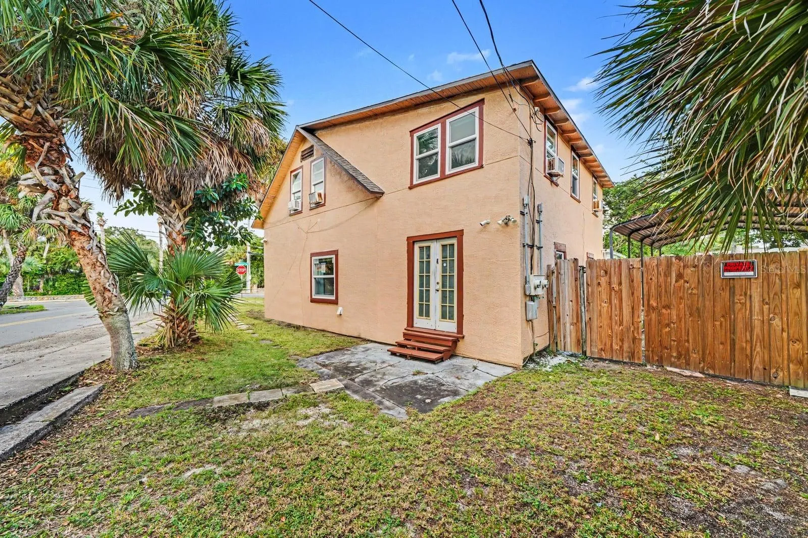 Front Exterior with Palm Trees, Landscaping & Wooden Fence Gate